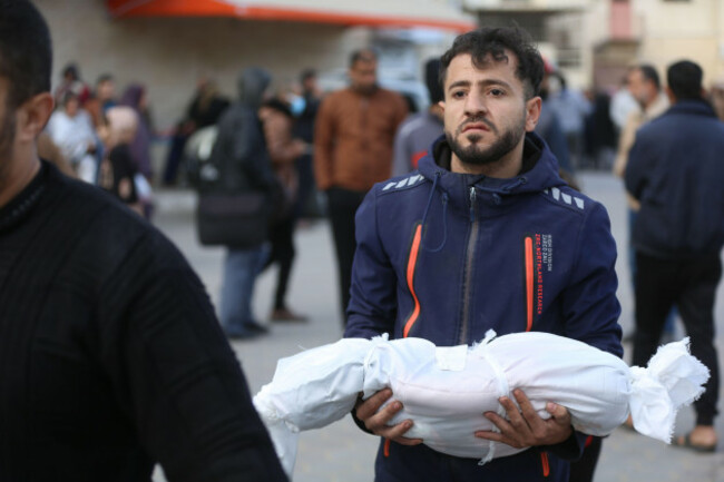 gaza-24th-dec-2023-a-man-holds-the-body-of-a-victim-at-a-hospital-in-central-gaza-strip-city-of-deir-el-balah-on-dec-23-2023-the-death-toll-of-palestinians-from-israeli-attacks-in-the-gaza-stri