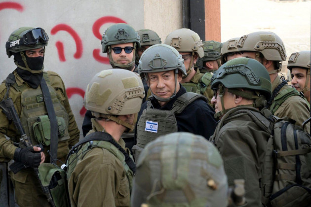 israeli-prime-minister-benjamin-netanyahu-center-wears-a-protective-vest-and-helmet-as-he-receives-a-security-briefing-with-commanders-and-soldiers-in-the-northern-gaza-strip-on-monday-dec-25-20