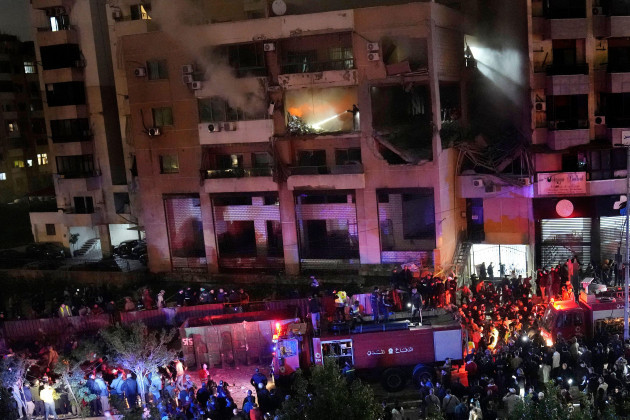 Люди собираются возле поврежденного здания после мощного взрыва в южном пригороде Бейрута, Ливан, во вторник, 2 января 2024 года, в эфире ливанского телеканала «Хезболла».