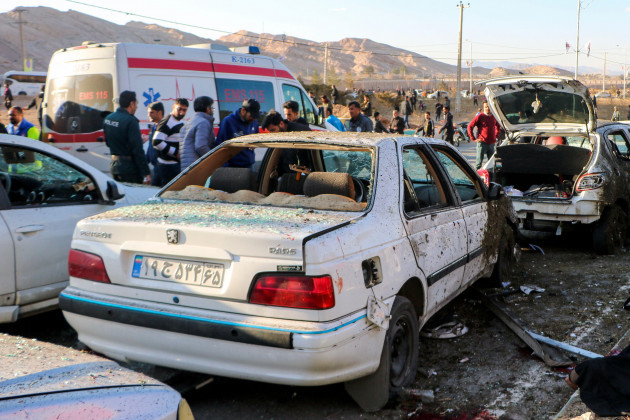 people-stay-next-to-destroyed-cars-after-an-explosion-in-kerman-iran-wednesday-jan-3-2024-iran-says-bomb-blasts-at-an-event-honoring-a-prominent-iranian-general-slain-in-a-u-s-airstrike-in-2020