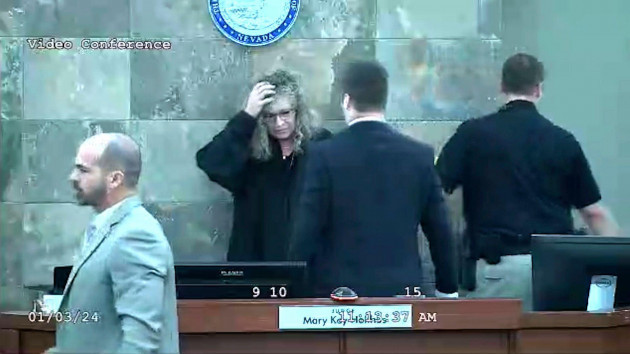 in-this-image-from-video-provided-by-the-clark-county-district-court-judge-mary-kay-holthus-is-seen-cradling-her-head-after-a-defendant-launched-over-her-desk-during-his-sentencing-in-a-felony-batter