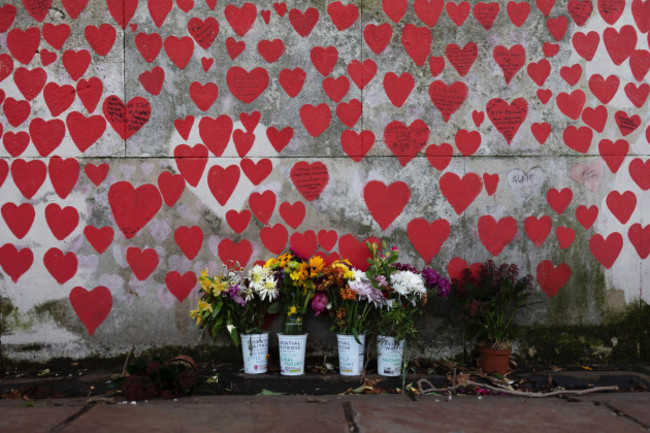 london-uk-4th-jan-2024-flowers-are-seen-laying-next-to-the-national-covid-memorial-wall-to-pay-tributes-to-the-covid-deaths-over-200000-hearts-have-been-painted-to-date-on-the-wall-outside-st-th