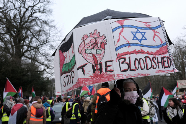 a-protestors-carries-a-sign-with-an-israeli-and-palestinian-flag-and-a-heart-in-the-middle-during-a-demonstration-outside-the-international-court-of-justice-in-the-hague-netherlands-thursday-jan