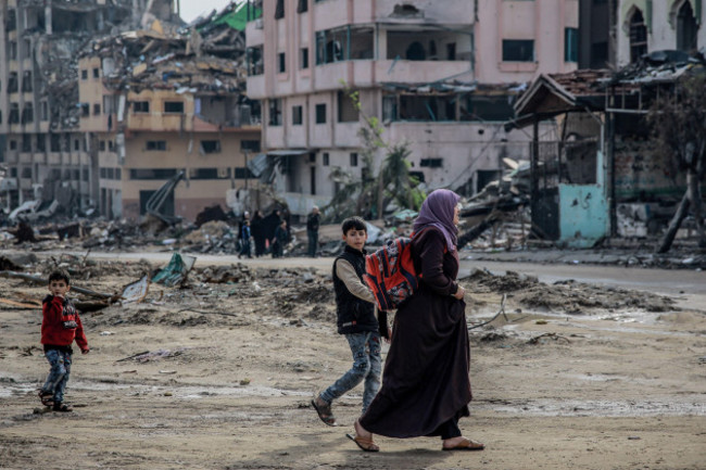 gaza-city-palestinian-territories-15th-jan-2024-a-palestinian-woman-walks-with-children-across-the-destroyed-sheikh-radwan-neighbourhood-in-gaza-city-after-one-hundred-days-of-the-isarel-hamas-wa