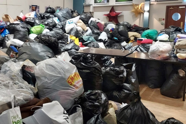 Bags of clothing and sleeping bag donations are piled in the Tiglin offices.
