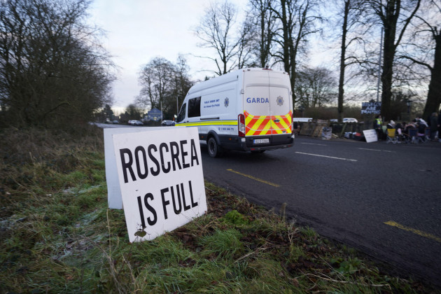 a-garda-van-passes-protesters-at-the-racket-hall-hotel-in-roscrea-co-tipperary-demonstrating-over-plans-to-house-asylum-seeker-family-applicants-in-the-hotel-picture-date-monday-january-15-2024