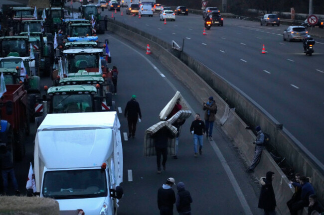 farmers-carry-mattresses-to-camp-on-a-highway-monday-jan-29-2024-in-argenteuil-north-of-paris-protesting-farmers-were-encircling-paris-with-tractor-barricades-and-drive-slows-on-monday-using-th