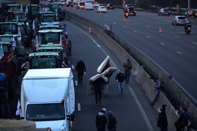 farmers-carry-mattresses-to-camp-on-a-highway-monday-jan-29-2024-in-argenteuil-north-of-paris-protesting-farmers-were-encircling-paris-with-tractor-barricades-and-drive-slows-on-monday-using-th