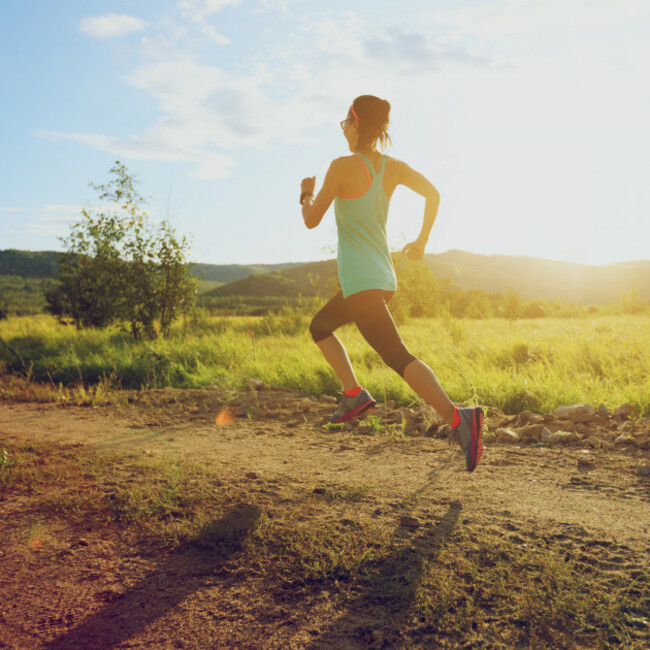 youngtrailrunnerwomanrunningonsunsetforest