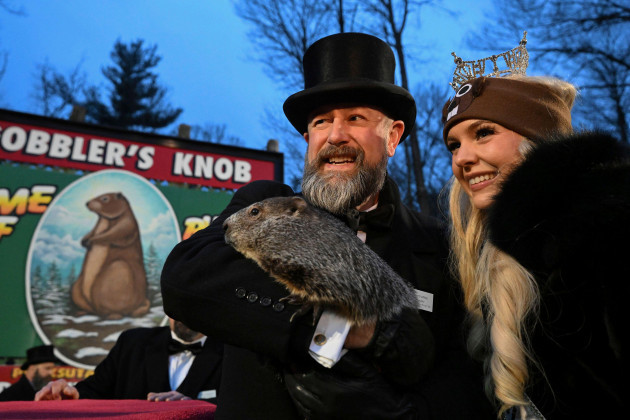 groundhog-club-handler-a-j-dereume-holds-punxsutawney-phil-the-weather-prognosticating-groundhog-while-posing-for-a-photo-with-miss-pennsylvania-miranda-moore-during-the-138th-celebration-of-ground