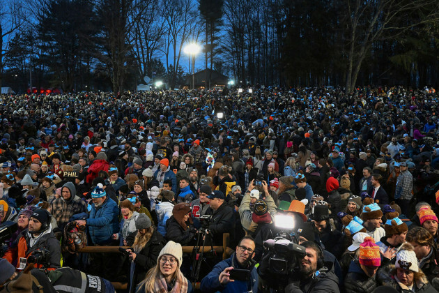 La multitud observa las festividades mientras Punxsutawney Phil espera el clima mientras la marmota sale y hace sus predicciones durante la celebración del 138º Día de la Marmota en el gobbl.