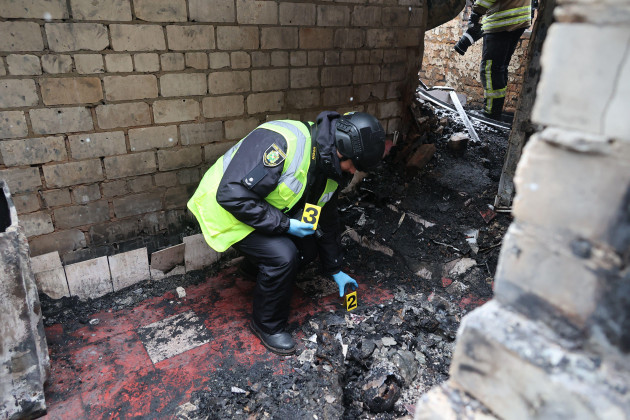 kharkiv-ukraine-february-10-2024-a-law-enforcer-places-evidence-number-cards-at-a-house-where-people-burnt-alive-that-caught-fire-as-a-result-of-the-russian-drone-attack-on-an-oil-depot-in-the-n