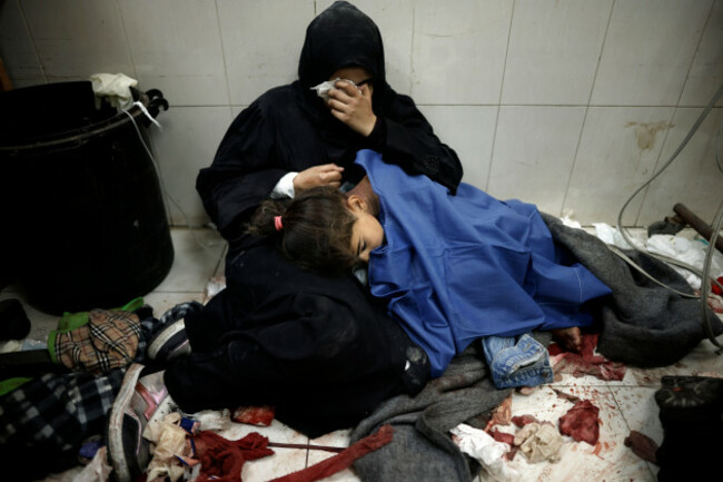 a-palestinian-woman-cries-as-she-sits-next-to-her-girl-wounded-in-the-israeli-bombardment-of-the-gaza-strip-while-receiving-treatment-at-the-nasser-hospital-in-khan-younis-southern-gaza-strip-monday