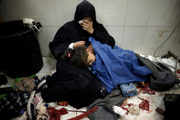 a-palestinian-woman-cries-as-she-sits-next-to-her-girl-wounded-in-the-israeli-bombardment-of-the-gaza-strip-while-receiving-treatment-at-the-nasser-hospital-in-khan-younis-southern-gaza-strip-monday