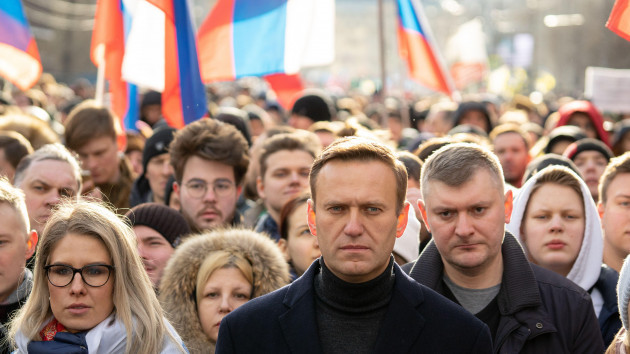moscow-russia-29-february-2020-lubov-sobol-abd-aleksey-navalny-on-march-in-memory-of-boris-nemtsov-people-flag-and-poster-on-the-background