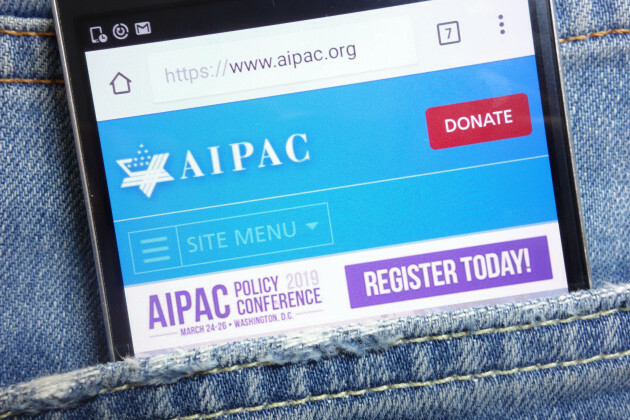 Веб-сайт AIPAC отображается на смартфоне и спрятан в кармане джинсов