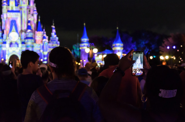 a-person-capturing-a-photo-of-the-disney-castle-on-their-cell-phone-at-disney-world-in-orlando-florida