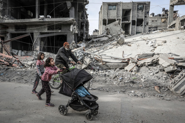 rafah-palestinian-territories-01st-mar-2024-palestinians-walk-past-buildings-destroyed-by-israeli-airstrikes-in-the-southern-gaza-strip-city-of-rafah-credit-abed-rahim-khatibdpaalamy-live-new