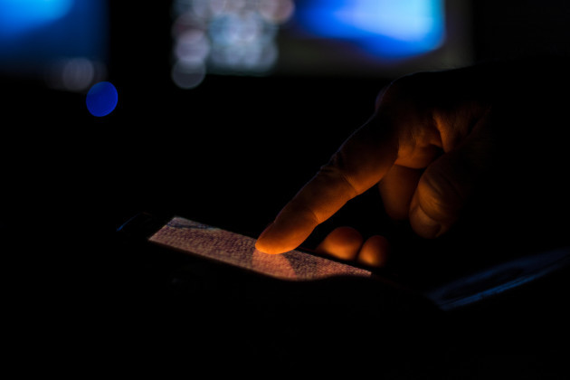 man-typing-on-mobile-phone-in-a-dark-room