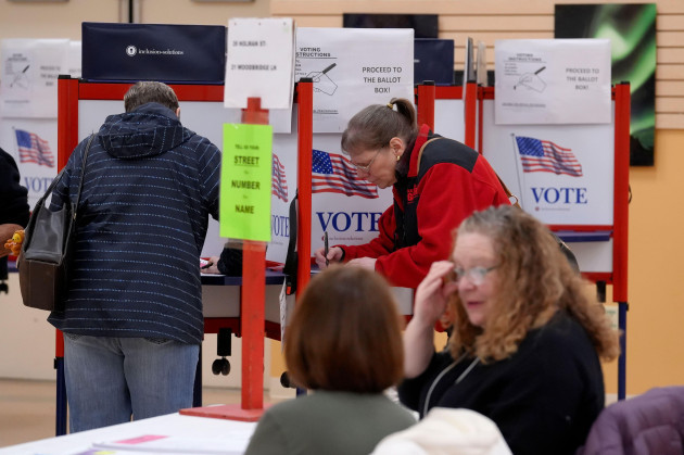 voters-top-fill-out-a-ballots-as-election-workers-below-look-on-at-a-polling-place-tuesday-march-5-2024-in-attleboro-mass-massachusetts-is-one-of-15-states-and-one-territory-holding-primary