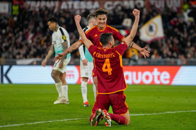romas-bryan-cristante-front-is-congratulated-by-paulo-dybala-after-scoring-his-sides-4th-during-the-europa-league-round-of-sixteen-first-leg-soccer-match-between-roma-and-brighton-and-hove-albion
