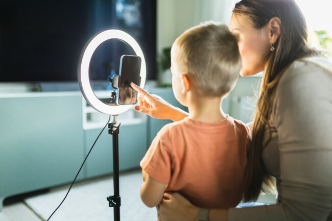 mother-live-streaming-with-son-on-smart-phone-with-ring-light-at-home