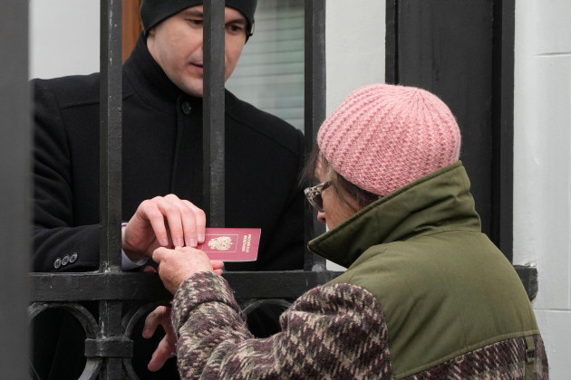a-russian-embassy-security-guard-checks-the-passport-of-a-russian-woman-who-queued-at-the-russian-embassy-in-warsaw-poland-sunday-march-17-2024-to-cast-her-vote-on-the-last-day-of-the-three-day-pr