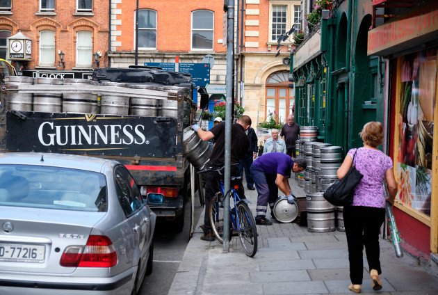 guinness-beer-delivery-to-pub-in-dublin-man-unload-truck-of-barrels-while-other-rolls-them-towards-ground-opening