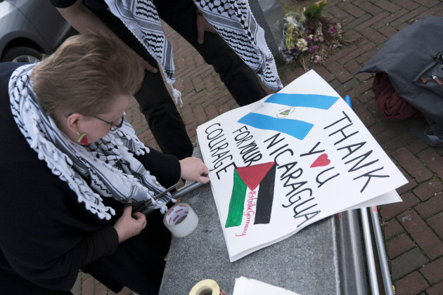 a-pro-palestinian-activist-works-on-a-protest-poster-near-the-international-court-of-justice-or-world-court-in-the-hague-netherlands-monday-april-8-2024-prior-to-the-start-of-a-two-days-hearing