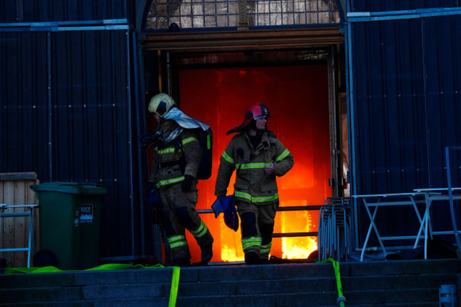 firefighters-walk-out-of-the-main-entrance-as-the-old-stock-exchange-burns-in-copenhagen-denmark-tuesday-april-16-2024-one-of-copenhagens-oldest-buildings-is-on-fire-and-its-iconic-spire-has-col