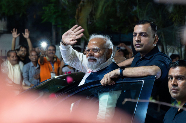 narendra-modi-leader-of-the-bharatiya-janata-party-bjp-and-indian-prime-minister-waves-to-supporters-during-a-roadshow-in-an-election-campaign-in-guwahati-asam-india-on-april-16-2024-credit-da