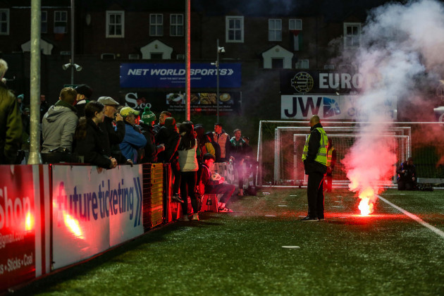 a-flare-lands-on-the-edge-of-the-pitch-after-it-was-thrown-over-the-top-of-the-shamrock-rovers-fans