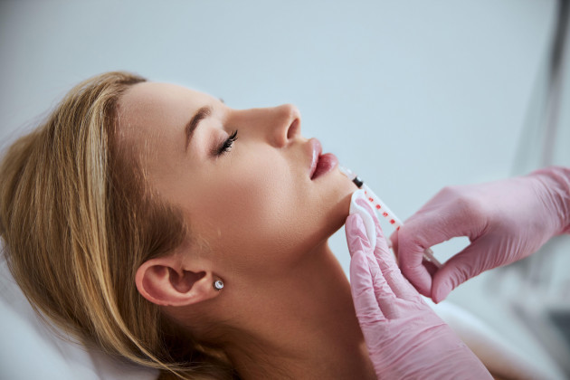 professional-cosmetologist-injecting-a-dermal-filler-into-the-patient-lips