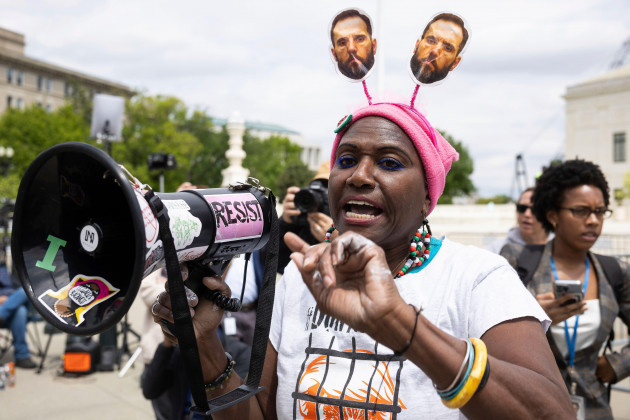 nadine-otego-seiler-wears-images-of-special-counsel-jack-smith-on-her-head-as-she-protests-outside-the-u-s-supreme-court-april-25-2024-after-oral-arguments-on-trump-v-united-states-a-case-on-wheth