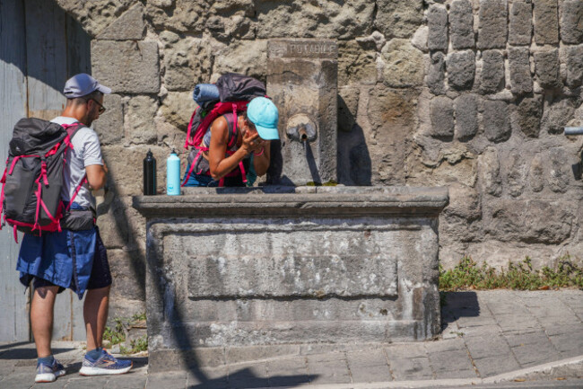 viterbo-lazio-italy-15-august-2023-backpackers-cooling-off-at-a-water-fountain-in-viterbo-central-italy-on-a-hot-august-day-as-temperatures-reach-34celsius-today-july-was-officially-earths-hot