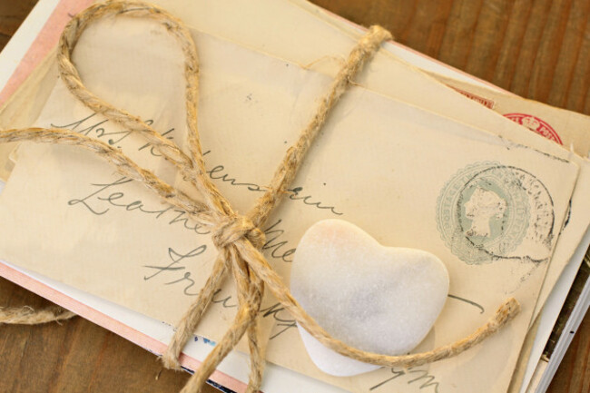 stone-heart-with-old-tied-letters-on-wooden-desk