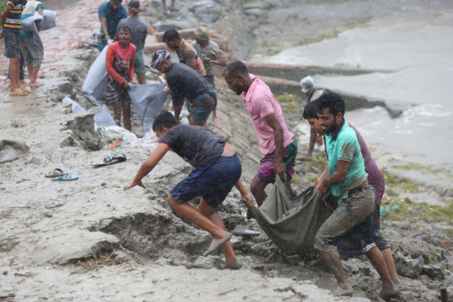 khulna-27th-may-2024-locals-repair-an-embankment-damaged-during-cyclone-remal-in-khulna-bangladesh-on-may-27-2024-at-least-seven-people-died-in-bangladesh-due-to-the-devastations-of-cyclone-rema