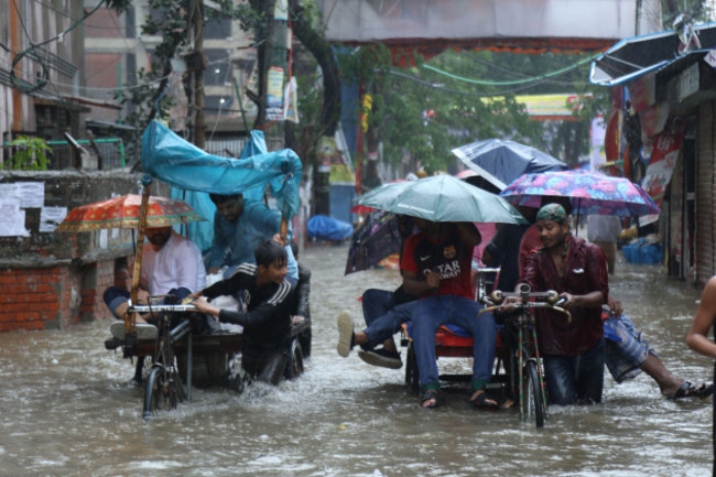 dhaka-27th-may-2024-people-take-flatbed-tricycles-on-a-waterlogged-street-in-dhaka-bangladesh-may-27-2024-at-least-seven-people-died-in-bangladesh-due-to-the-devastations-of-cyclone-remal-whic