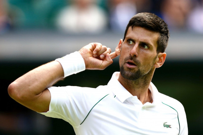 serbias-novak-djokovic-puts-his-ear-to-the-crowd-in-his-match-against-italys-jannik-sinner-in-the-quarter-finals-match-on-centre-court-on-day-nine-of-the-2022-wimbledon-championships-at-the-all-engl