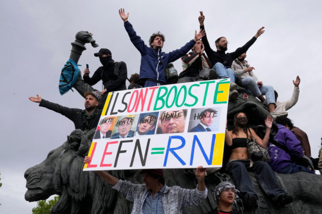 a-protester-holds-an-anti-far-right-banner-showing-the-faces-of-french-presidents-and-the-word-honte-or-shame-during-a-rally-in-paris-saturday-june-15-2024-anti-racism-groups-joined-french-uni