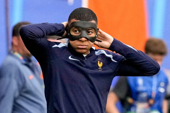 frances-kylian-mbappe-warms-up-with-a-face-mask-prior-a-group-d-match-between-the-netherlands-and-france-at-the-euro-2024-soccer-tournament-in-leipzig-germany-friday-june-21-2024-ap-photoanton