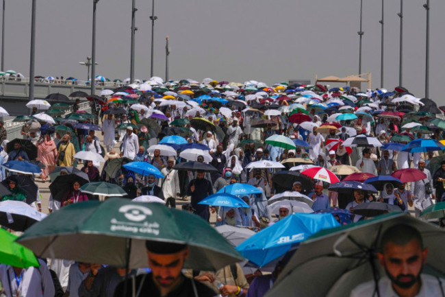 file-muslim-pilgrims-use-umbrellas-to-shield-themselves-from-the-sun-as-they-arrive-to-cast-stones-at-pillars-in-the-symbolic-stoning-of-the-devil-the-last-rite-of-the-annual-hajj-in-mina-near-th