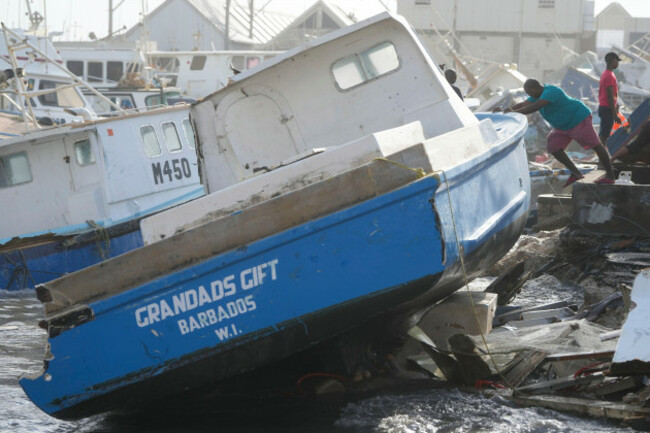 a-fisherman-pushes-a-boat-damaged-by-hurricane-beryl-at-the-bridgetown-fisheries-in-barbados-monday-july-1-2024-ap-photoricardo-mazalan
