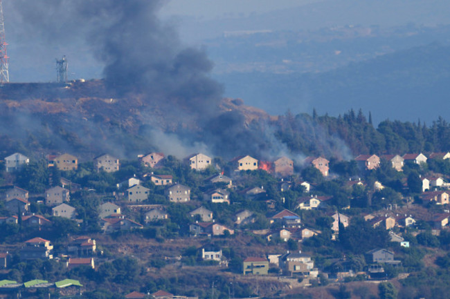 file-fires-and-black-smoke-rise-from-between-the-houses-of-the-northern-israeli-border-town-of-metula-which-was-hit-by-hezbollah-shelling-as-seen-from-the-lebanese-side-of-the-lebanese-town-of-mar