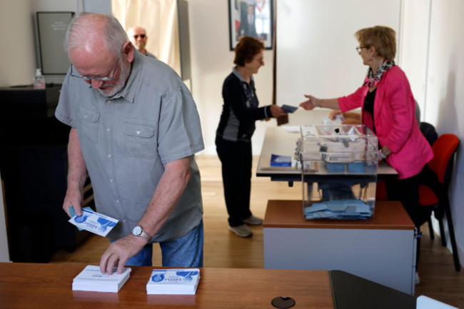 a-man-picks-up-ballots-in-a-the-voting-station-during-the-second-round-of-the-legislative-elections-sunday-july-7-2024-in-olwisheim-eastern-france-france-votes-sunday-in-pivotal-runoff-elections