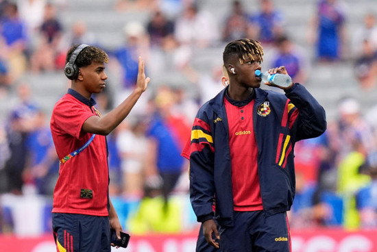 spains-lamine-yamal-and-nico-williams-right-take-a-walk-on-the-pitch-before-a-semifinal-match-between-spain-and-france-at-the-euro-2024-soccer-tournament-in-munich-germany-tuesday-july-9-2024