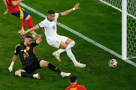 kylian-mbappe-of-france-center-and-spains-goalkeeper-unai-simon-vie-for-the-ball-during-a-semifinal-match-between-spain-and-france-at-the-euro-2024-soccer-tournament-in-munich-germany-tuesday-ju