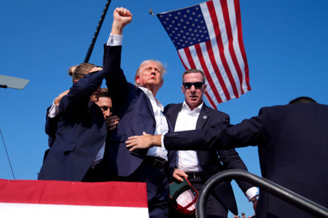 republican-presidential-candidate-former-president-donald-trump-gestures-as-he-is-surrounded-by-u-s-secret-service-agents-as-he-leaves-the-stage-at-a-campaign-rally-saturday-july-13-2024-in-butle