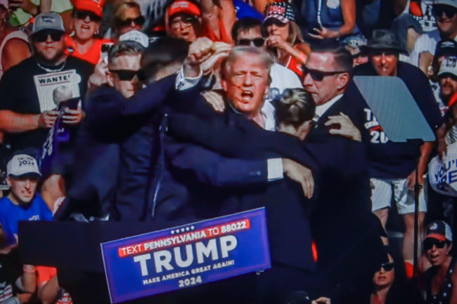 in-this-photo-illustration-a-screen-shows-former-us-president-donald-trump-shot-in-the-ear-at-a-rally-he-was-holding-in-butler-former-us-president-donald-trump-was-wounded-in-a-shooting-at-a-rally-h