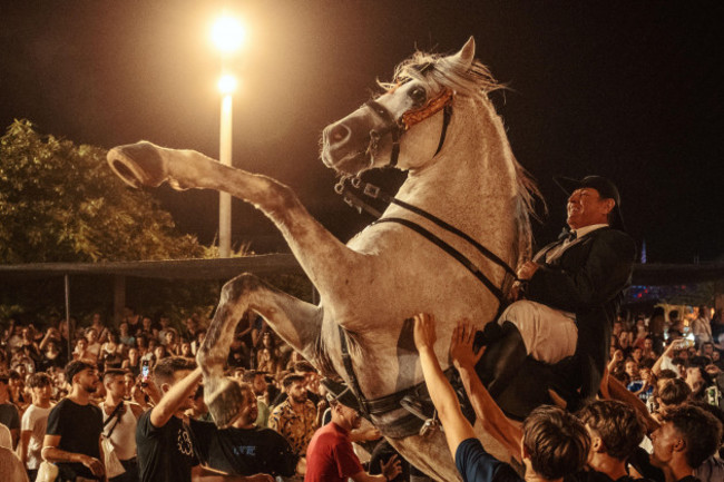 es-castell-spain-24th-july-2024-a-caixer-horse-rider-rears-up-on-his-horse-surrounded-by-a-cheering-crowd-during-the-traditional-jaleo-at-the-sant-jaume-festival-in-es-castell-credit-matthi